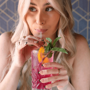 Lady is sipping fruit cocktail.